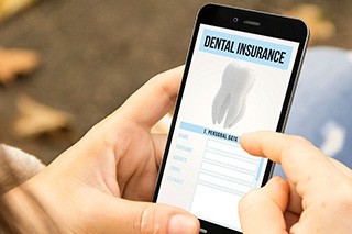 Patient looking at dental insurance form on phone outside