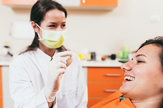 A dentist holding a woman’s extracted tooth 