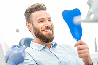 Man looking at smile in mirror