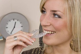 Woman holding her Invisalign tray