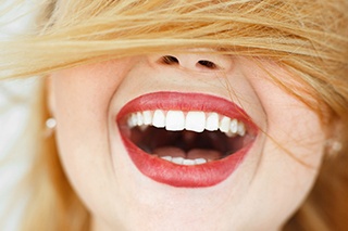 Woman’s face with hair covering top, big smile