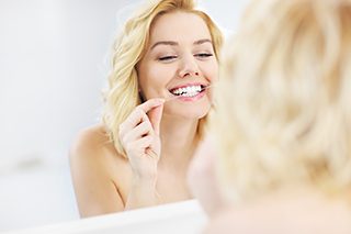 Woman flossing teeth