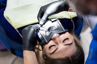 A dental dam being used on a female patient
