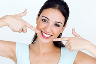 Woman pointing at her beautiful smile.