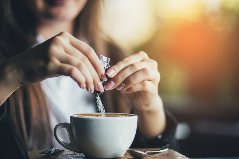 girl pouring sweetener into coffee