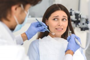 Patient looking frightened as dentist goes to work on them. 