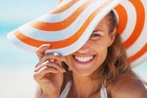 Woman in sun hat smiles after visiting Forth Worth cosmetic dentist