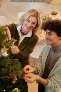 Two women decorating a Christmas tree